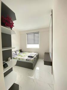 une petite chambre avec un lit et une fenêtre dans l'établissement DINO Home HACOM 1BR, à Kinh Dinh