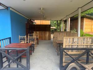 NongkhiawPetros Hostel的一组木桌和椅子,位于大楼前 更多31张照片