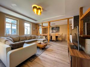 a living room with a couch and a tv at Alter Balken-Neuer Glanz - Ferienhaus Luna im Herzen Suhl Heinrichs in Suhl