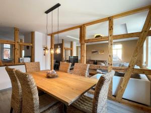 a dining room with a wooden table and chairs at Alter Balken-Neuer Glanz - Ferienhaus Luna im Herzen Suhl Heinrichs in Suhl +5 photos