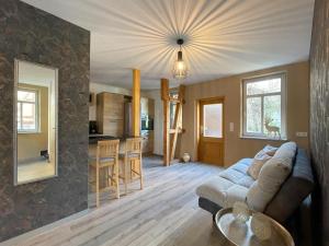 a living room with a couch and a kitchen at Alter Balken-Neuer Glanz - Ferienhaus Luna im Herzen Suhl Heinrichs in Suhl