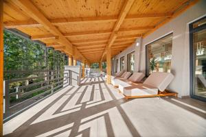 a porch with white chairs and a wooden ceiling at OzonWellness in Harghita-Băi