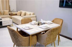 Una mesa de comedor y sillas en una sala de estar. en Marjaan Stays Luxury Guest House in Lahore Goldberg, en Lahore