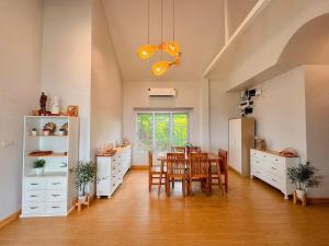 a kitchen and dining room with a table and chairs at Jacuzzi mine hills in Ban Mai