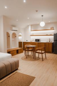 a bedroom with a bed and a table and a kitchen at Taupe Hotel in Chiang Mai