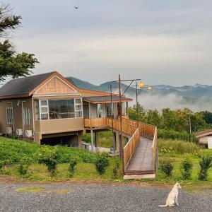 a house with a deck and a cat sitting in front of it at Jacuzzi mine hills in Ban Mai
