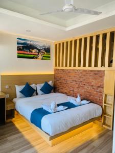 une chambre avec un grand lit avec un mur de briques dans l'établissement Pokhara Apartments Residence, à Pokhara