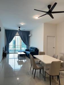 a living room with a table and a blue couch at Sunshine Residence in Ayer Itam