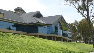 a building with a black roof on top of a hill at Riverside Oaks Golf Resort in Cattai