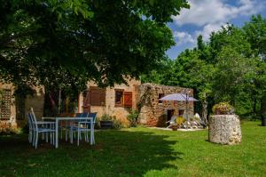 ein Tisch und Stühle im Hof eines Hauses in der Unterkunft Maison d'hôtes in Grézels
