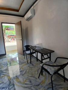 a room with a table and chairs and a window at correashomestay in Coron