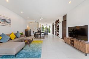 ein Wohnzimmer mit Sofa und Fernseher in der Unterkunft Bangtao Beach Gardens - Apartment F22 in Ban Lum Fuang