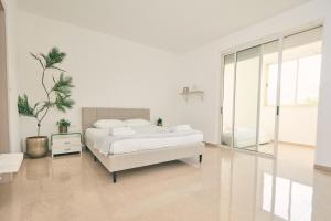 a white bedroom with a bed and a large window at אריה במדבר - וילה מושלמת עם בריכה פרטית מחוממת באילת in Eilat +42 photos