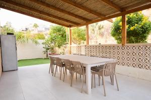 a white table and chairs on a patio at אריה במדבר - וילה מושלמת עם בריכה פרטית מחוממת באילת in Eilat