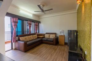 a living room with a couch and a ceiling fan at Pokhara Apartments Inn in Pokhara