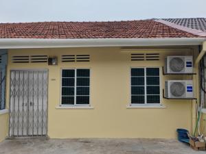 a yellow house with two windows and a gate at Zen Retreat KL in Kuala Lumpur