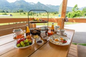 a breakfast table with food and drinks on a deck at Camping Danica Cottage Stan in Bohinj