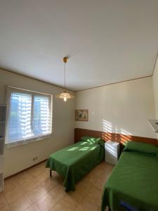 Crateri e coralli في ماسكالي: غرفة نوم بها سريرين ونافذة +16 صورة