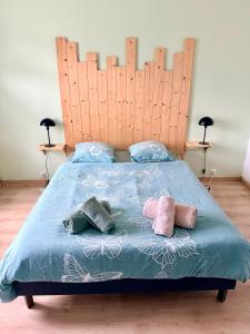 a bed with a wooden headboard and pillows on it at Très bel appartement au cœur des Vosges in Saulcy-sur-Meurthe +10 photos