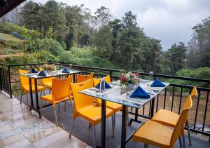 a row of tables with yellow chairs on a balcony at We Cay Holidays in Nikawatawana