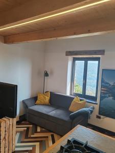 a living room with a couch and a television at Chalet La montagne enchantée in San Damiano Macra
