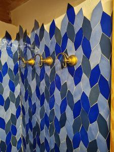 a bathroom with blue and white tiles on a wall at Chalet La montagne enchantée in San Damiano Macra
