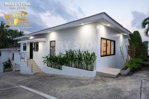 une maison blanche avec des plantes devant dans l'établissement Savaya Samui (Villa Malena), à Ban Ko Khwan