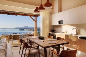 a kitchen and dining room with a table and a large window at Thaleri Villa in Pyrgi