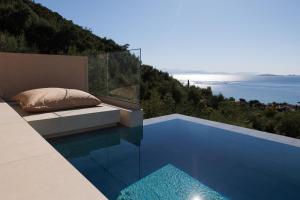 a pool with a bed and a view of the ocean at Thaleri Villa in Pyrgi