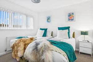 - une chambre avec 2 lits en bleu et blanc dans l'établissement Windrush Court, The Spacious & Comfy 3BR House By AltoLuxo Short Lets & Serviced Accommodation With Free WiFi & Parking, à Thornbury
