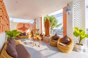 ein Wohnzimmer mit Korbstühlen und einem Tisch in der Unterkunft Cham Charm Apartment Hotel Mui Ne in Mui Ne