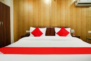 Un dormitorio con una cama con almohadas rojas. en Hotel O Uday, en Jaipur