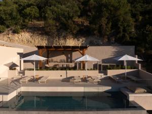 a swimming pool with umbrellas and chairs and a swimming poolvisor at Thaleri Villa in Pyrgi +19 photos