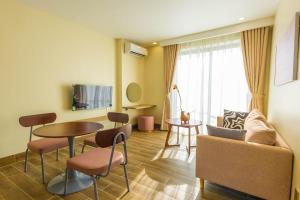 ein Wohnzimmer mit Sofa und Tisch in der Unterkunft Cham Charm Apartment Hotel Mui Ne in Mui Ne