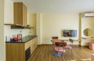 eine Küche mit Tisch und Stühlen in einem Zimmer in der Unterkunft Cham Charm Apartment Hotel Mui Ne in Mui Ne