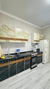 a kitchen with a sink and a refrigerator at Expo New Life Astana in Astana