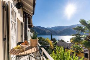 a balcony with a table and a view of the water at Once in a Lifetime - by MyHomeInComo in Laglio
