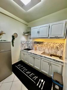 een keuken met witte kasten en een aanrechtblad bij Studio B living in Agadir