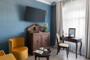 a living room with a desk and a chair and a table at Schloßhotel Althörnitz Neubau in Hörnitz