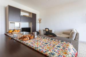 een woonkamer met een bed met een dienblad met brood bij Apt Grecale e Ponente vista mare - Salento Reservation in Isola della Malva