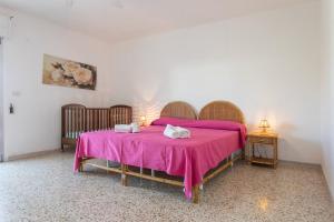 een slaapkamer met een bed met een roze deken bij Apt Grecale e Ponente vista mare - Salento Reservation in Isola della Malva