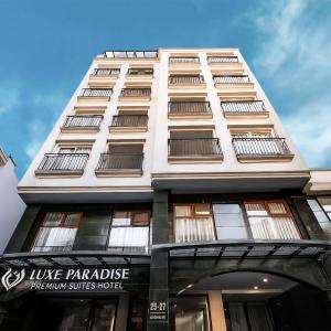 a tall white building with a sign on it at Luxe Paradise Premium Hotel Nguyen Khac Hieu in Hanoi