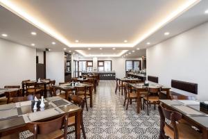 a dining room with wooden tables and chairs at Luxe Paradise Premium Hotel Nguyen Khac Hieu in Hanoi +130 photos