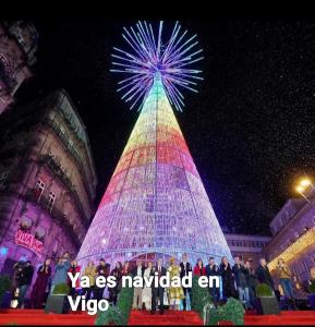 a large christmas tree is lit up at night at La bahia in Moaña