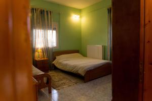 a small bedroom with a bed and a window at Adam's House in Tríkala