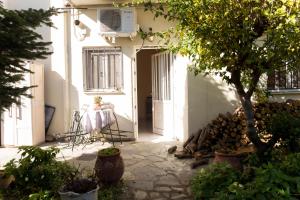 a house with a table and a tree in the courtyard at Adam's House in Tríkala