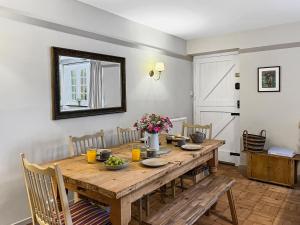 a dining room with a wooden table and chairs at Bossington Green Cottage in Porlock +14 photos