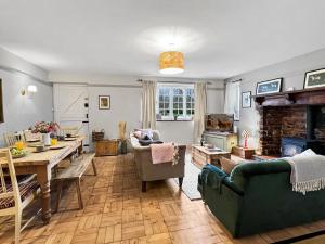 a living room with a table and a couch and a fireplace at Bossington Green Cottage in Porlock