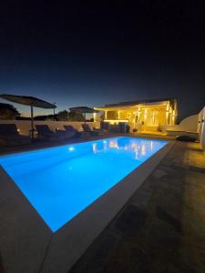 a swimming pool lit up at night at Magia's Residence in Naousa