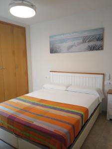 a bedroom with a bed with a colorful blanket on it at vistas panoranicas al mar desde su terraza in Moncófar